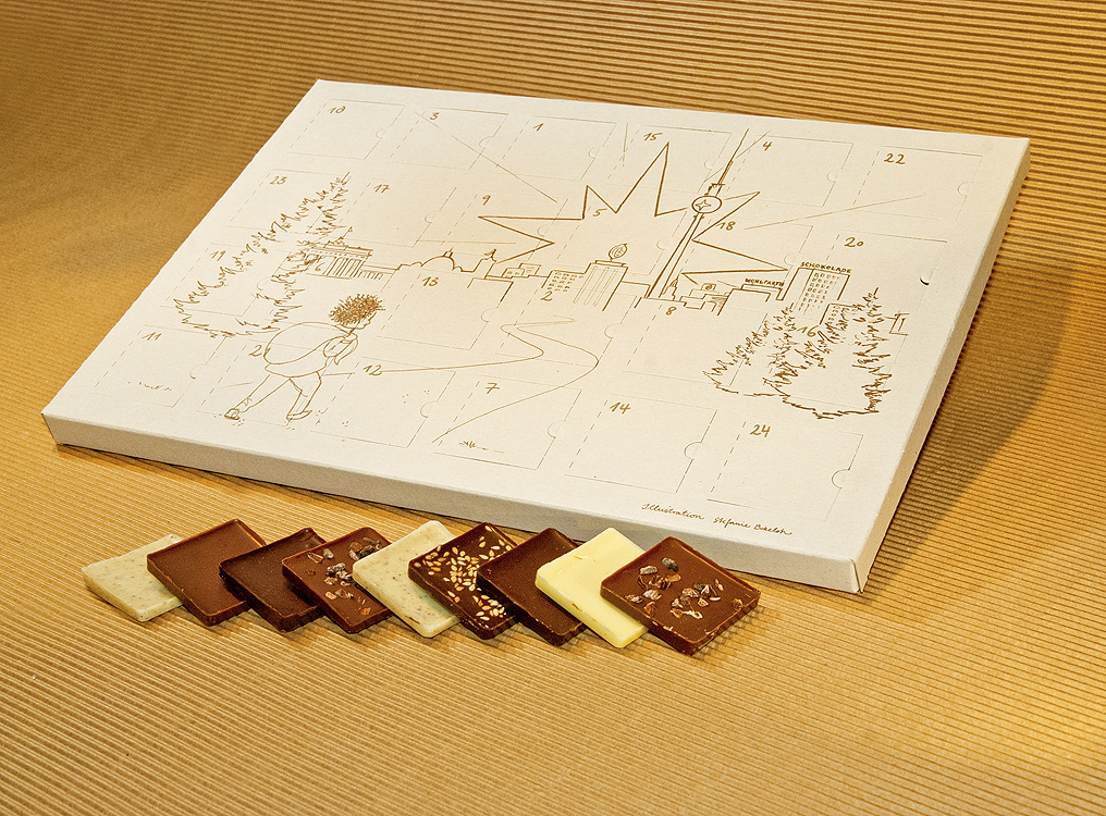 Ein Adventskalender mit Schokoladden-Quadrate von Wohlfarth Schokolade aus Berlin auf einem Tisch mit Pappe im Gelbton